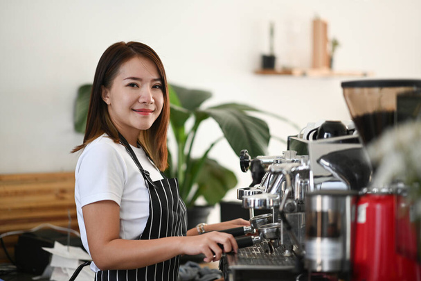 コーヒーショップでお客様の注文のためのコーヒーのカップを準備する女性アジアバリスタ. - 写真・画像