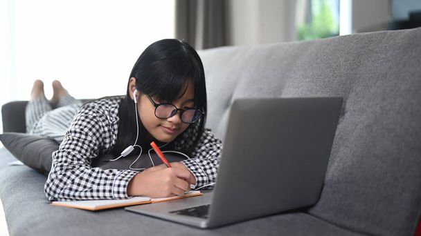 Азійська студентська відеоконференція Навчання з вчителем на ноутбуці у вітальні.. - Фото, зображення