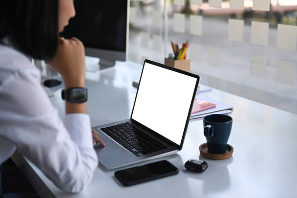 Вид збоку бізнес-леді зосереджений на роботі на ноутбуці в сучасному офісі
. - Фото, зображення
