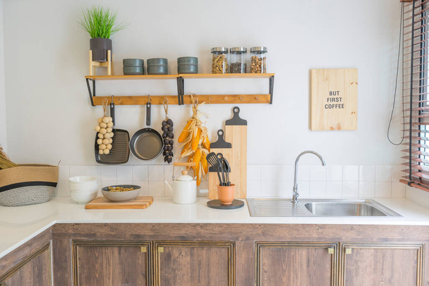 Arrangement von Trockenlebensmitteln, Gewürzen und Keramik Küchengeräte hängen auf dem Land Regale in rustikalen Wohnküche. - Foto, Bild