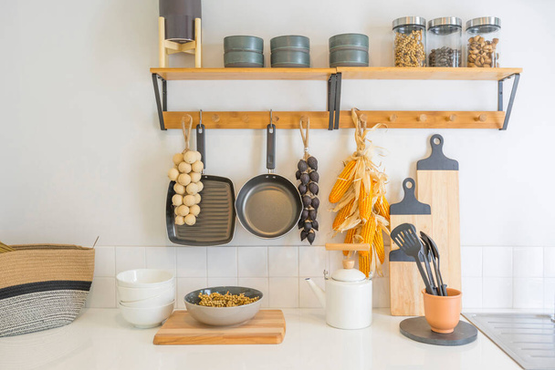 Arrangement of dry food products, spices and ceramics kitchen equipment hanging on country shelves in rustic home kitchen. - Photo, Image