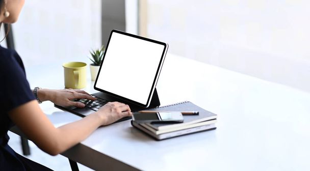 Žena na volné noze pracující nebo zkontrolovat informace z webových stránek na počítači tabletu na svém pracovišti. - Fotografie, Obrázek
