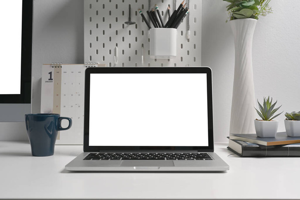 Workspace laptop biały ekran na kreatywnym biurku. - Zdjęcie, obraz