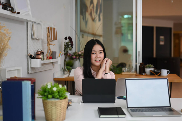 Yaratıcı ofisteki tablet bilgisayarının önünde oturan genç kadın grafik tasarımcısının portresi. - Fotoğraf, Görsel