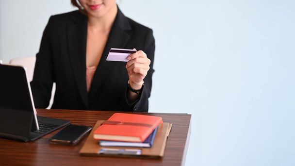 Femme d'affaires détenant une carte de crédit et utilisant un ordinateur tablette pour faire des achats en ligne ou entrer dans le système bancaire Internet. - Photo, image