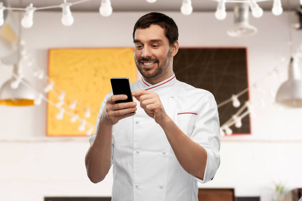 happy smiling male chef with smartphone - Фото, изображение