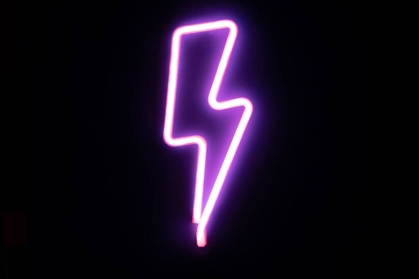 Purple lightning bolt mounted neon signs. High-voltage neon symbol, light banner design element colorful modern design trends. Cyberpunk concept - Fotó, kép