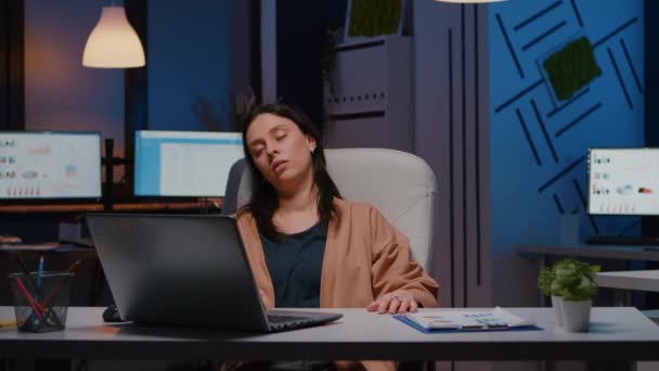 Uupunut yrittäjä nainen nukkuu kannettavan tietokoneen edessä analysoidessaan rahoitustilastoja - Materiaali, video