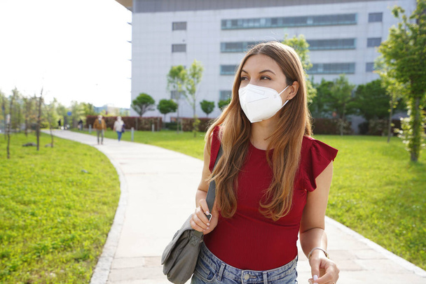 Beautiful young business woman wearing FFP2 KN95 face mask going to work looking to the side - Photo, Image