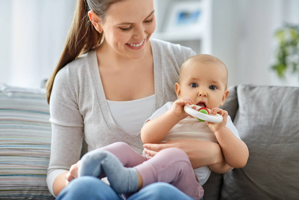 mother and little baby with teething toy at home - Foto, Imagen