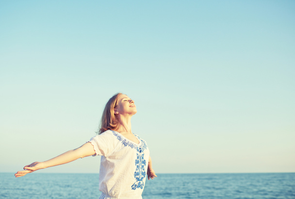 щаслива молода жінка відкриває руки до неба і моря
 - Фото, зображення