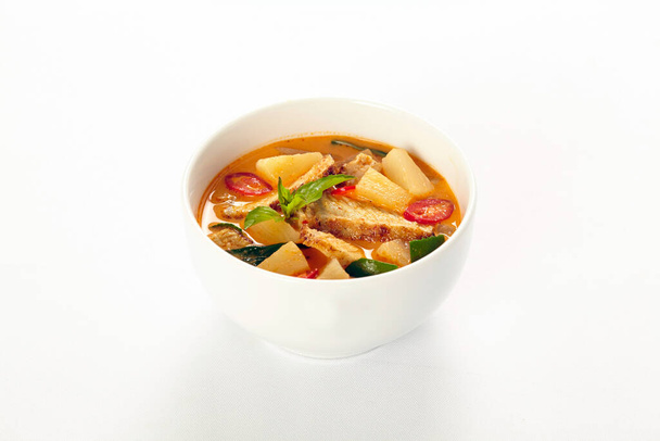 Жареная утка красный карри на белом фоне, тайская традиционная еда. - Фото, изображение