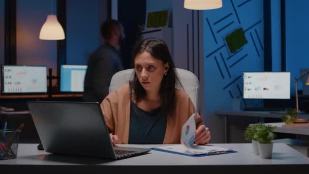 Overworked businesswoman analyzing financial graphs on clipboard - Footage, Video