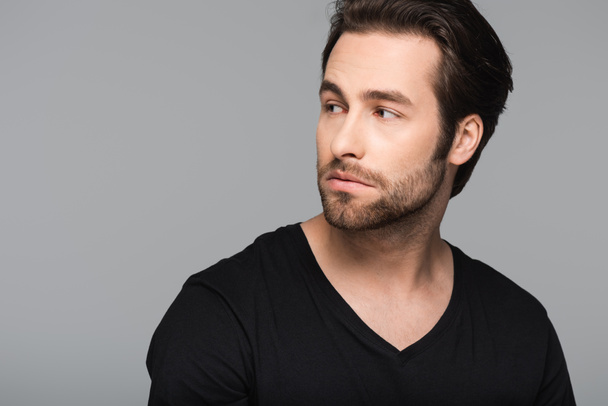 bearded and good-looking man in black t-shirt looking away isolated on gray - Photo, Image