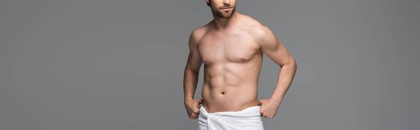 cropped view of shirtless man adjusting towel and standing isolated on grey, banner - Foto, immagini