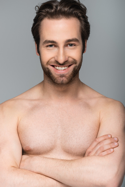 smiling shirtless man posing and looking at camera isolated on grey  - Fotografie, Obrázek