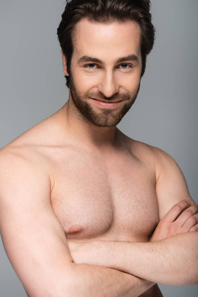 good-looking shirtless man smiling and posing with crossed arms isolated on grey  - Foto, immagini