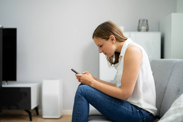 Woman With Neck Pain Sitting Using Mobile Phone - Foto, imagen