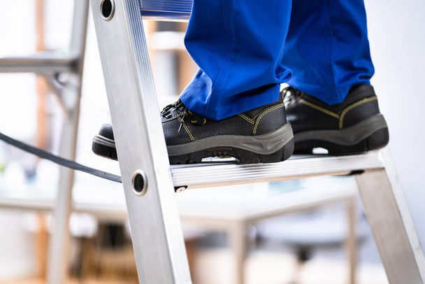 Man In Shoes Climbing Step Ladder. Safety And Insurance - Foto, immagini