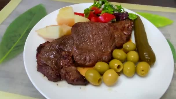 Žhavý čerstvě grilovaný žebírkový steak na bílém s pečenými brambory a zeleninou. HD - Záběry, video