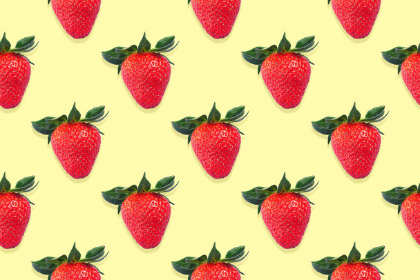 Seamless pattern of strawberries with green leaves on a yellow background - Fotografie, Obrázek