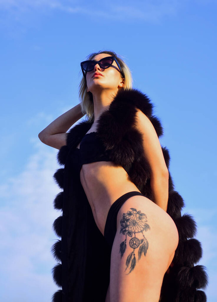 Flirty beauty. female beauty and fashion. woman has fit and slim body. luxury and success. sexy woman wear erotic lingerie and fur waistcoat. sensual girl in summer sunglasses on sky background - Φωτογραφία, εικόνα