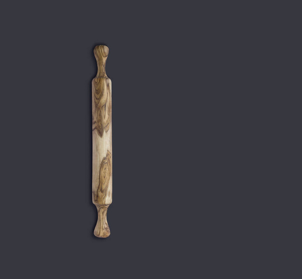 Top up view olive wooden rolling pin isolated on dark background. suitable for your design element. - Фото, изображение