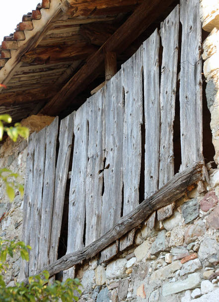 Деревянный крест, вырезанный между досками старого хлева, используемого крестьянами - Фото, изображение