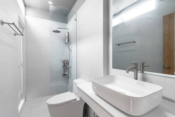 Fehér modern és fa fürdőszoba zuhanyzós kabin üveg és nagy tükör az apartmanban - Fotó, kép