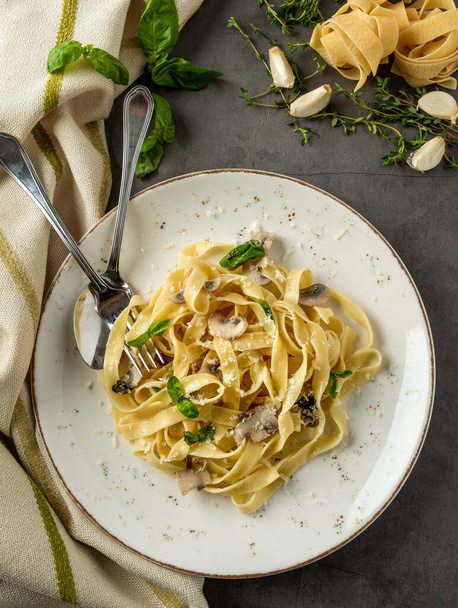 Pasta fettuccine mit Champignons und gebratenem Hühnerschinken in cremiger Käsesauce auf hellem Holzgrund - Foto, Bild