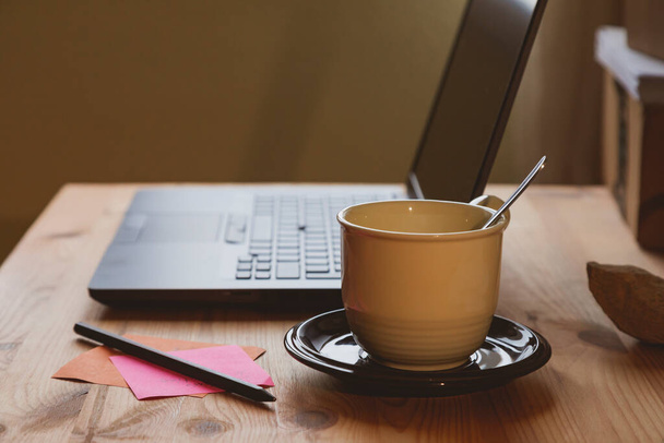 Domácí kancelář, příklad místa pro práci z domova, kde můžete vidět notebook a šálek kávy nebo horkého čaje, brzy ráno, v Madridu, Španělsko. Shoda pracovního a soukromého života. - Fotografie, Obrázek