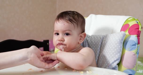 Mamãe alimenta o menino com uma colher e mão, comida familiar e conceito de paternidade. primeiros alimentos complementares e auto-alimentação - Filmagem, Vídeo