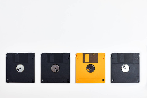 Varios disquetes de diferentes colores sobre un fondo blanco, tecnologías del pasado. - Foto, imagen