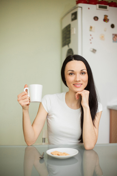 girl drinking tea with cookie in the morning  - Фото, зображення