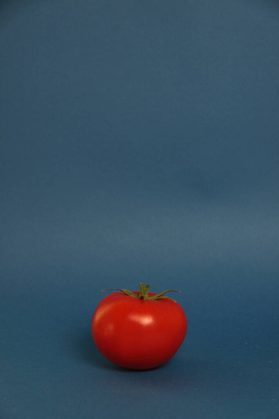 fresh tomato isolated on blue background healthy eating concept. Image contains copy space - Foto, imagen