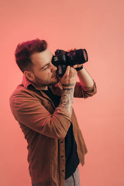 Man shooting somebody at his professional camera while posing - Fotografie, Obrázek