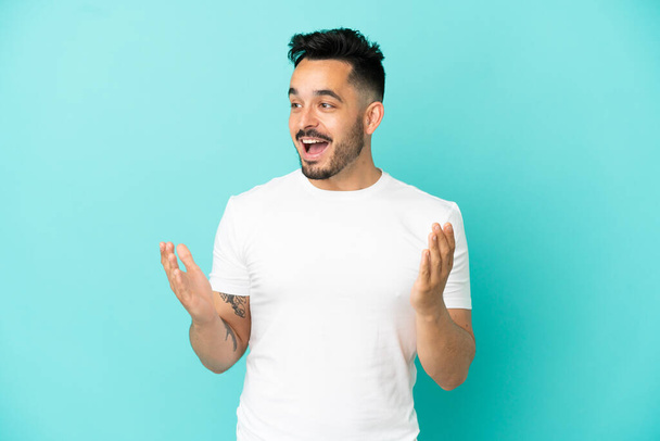 Young caucasian man isolated on blue background with surprise facial expression - Fotografie, Obrázek