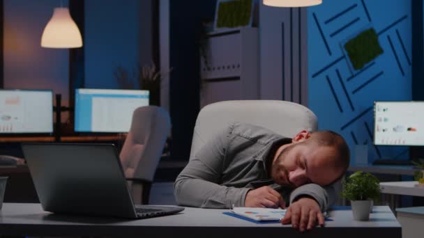 Yorgun, çok çalışan bir iş adamı yeni açılan iş ofisinde masa başında uyuyor. - Video, Çekim