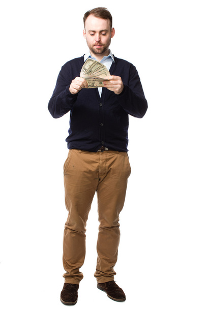 Young man eyeing up a handful of money - Foto, imagen