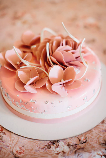 Pyöreä vaaleanpunainen kakku vaaleanpunaisia kukkia. Hääkakku. Syntymäpäiväjälkiruoka. Valikoiva painopiste. - Valokuva, kuva