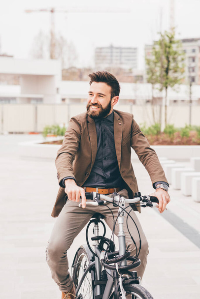Fiatal kortárs üzletember kerékpározás mosolygó környezetbarát - Fotó, kép