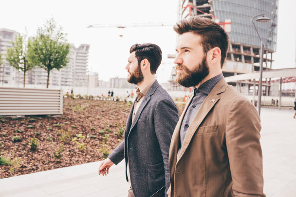 Due giovani colleghi barbuti uomini d'affari che camminano all'aperto - Foto, immagini