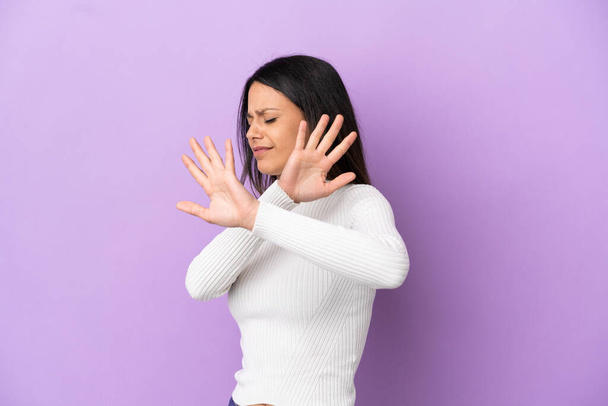 Young caucasian woman isolated on purple background nervous stretching hands to the front - Valokuva, kuva