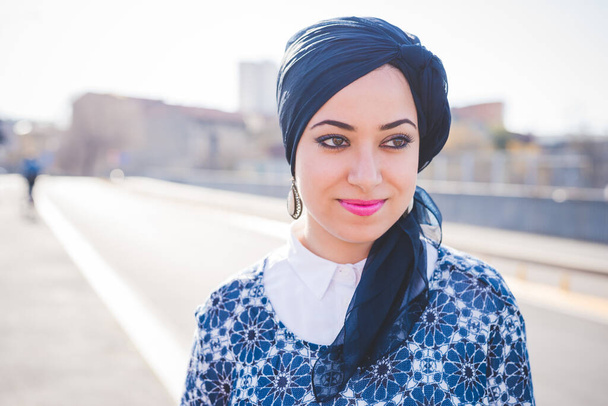 Junge Frau aus dem Mittleren Osten trägt Hijab und posiert draußen selbstbewusst und schaut weg - Foto, Bild