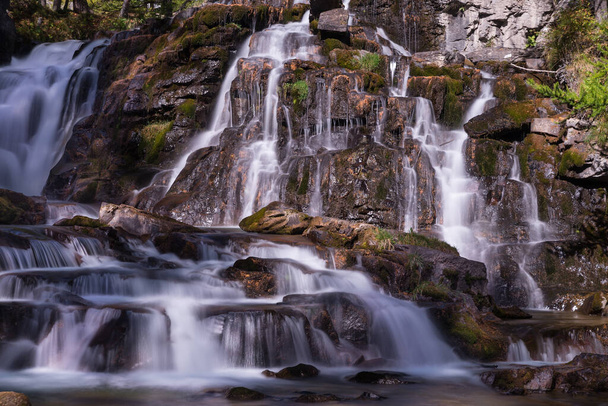 A beautiful view of a waterfall flowing over rocks - Zdjęcie, obraz