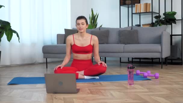Позитивна жінка сидить на йога мат розмовляти спілкується з тренером фітнесу
 - Кадри, відео