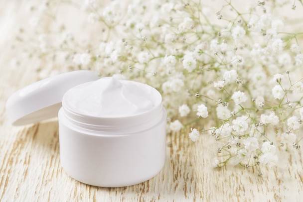 Moisture lotion or body cream in a white jar on a wooden table, copy space for text. - Foto, Imagem