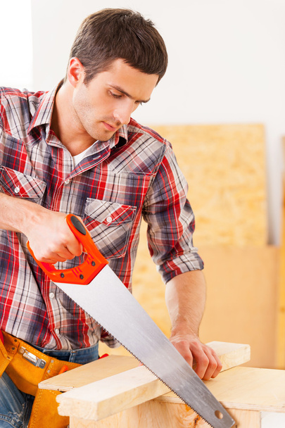 Handyman using saw. - Foto, afbeelding