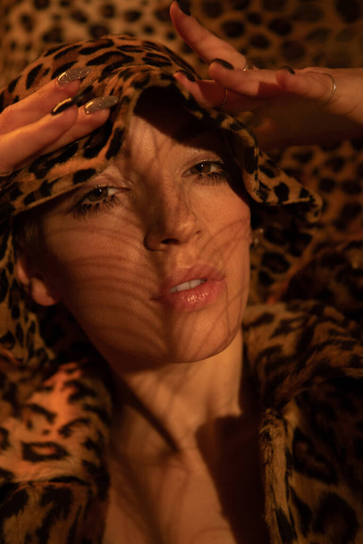 Woman wearing leopard look posing with open mouth and looking at the camera - Photo, image