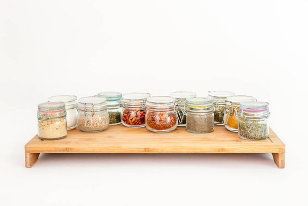 Group of assorted spice jars on bamboo table - Foto, Imagen